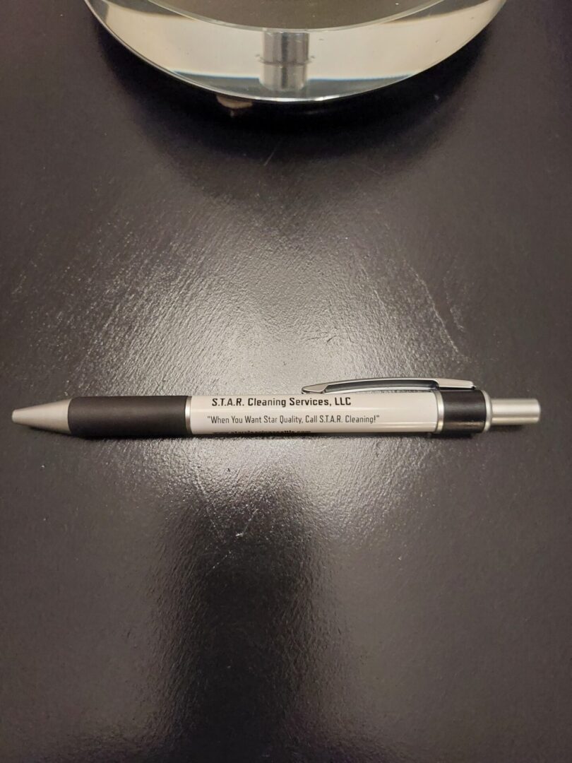 A pen in black and white placed on the black table